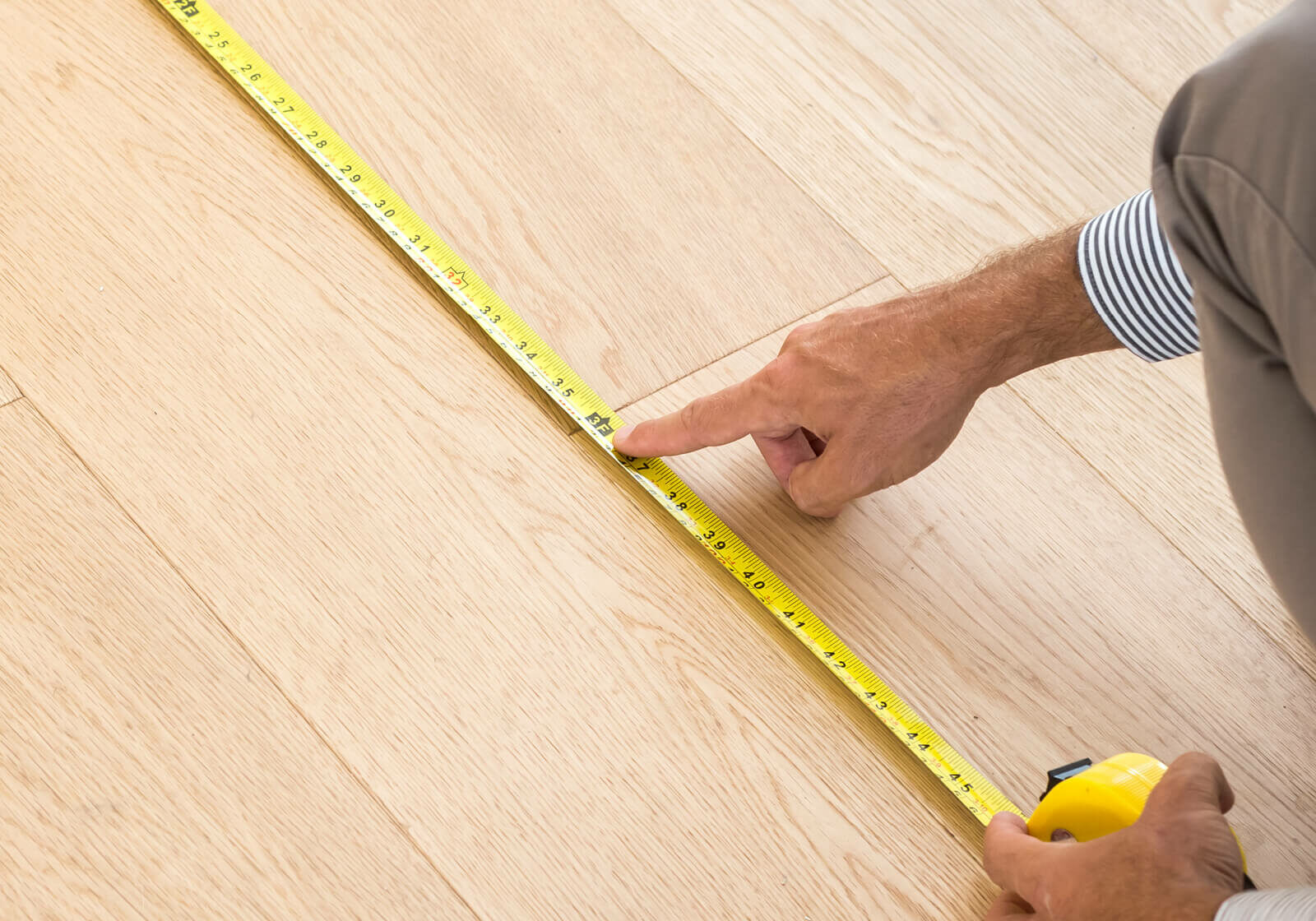 Man measuring laminate floor | America's Flooring Store